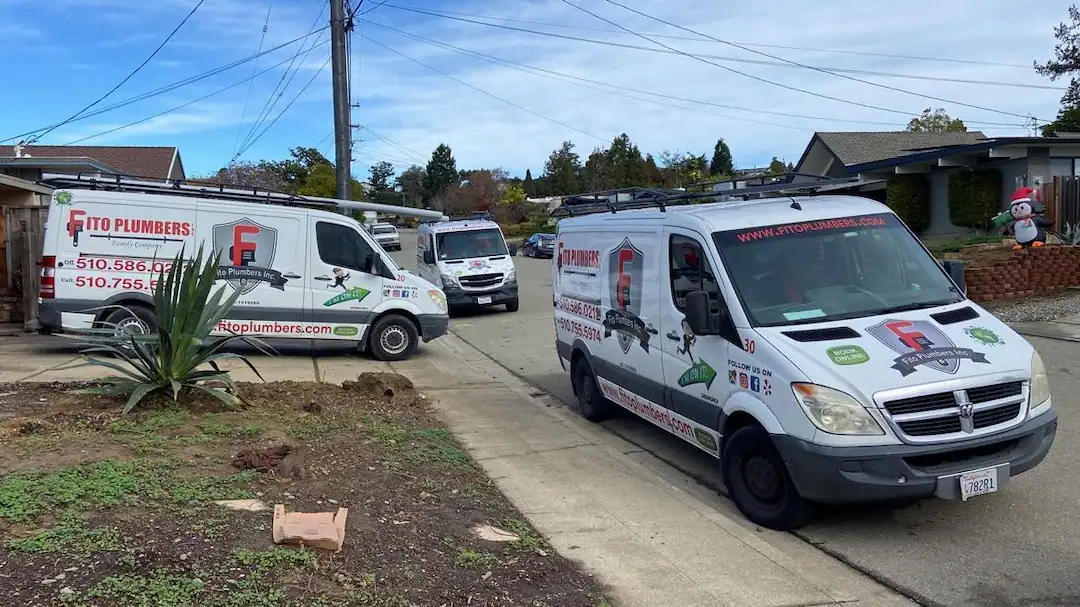 Fito white plumbing vans parked on a street