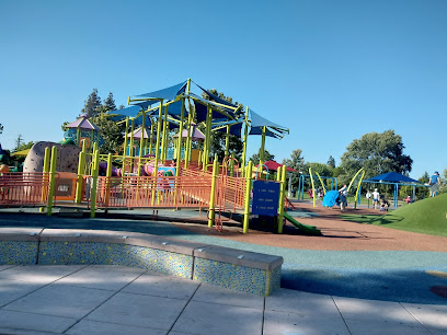 Playground equipment and slides at a public park under clear blue sky
