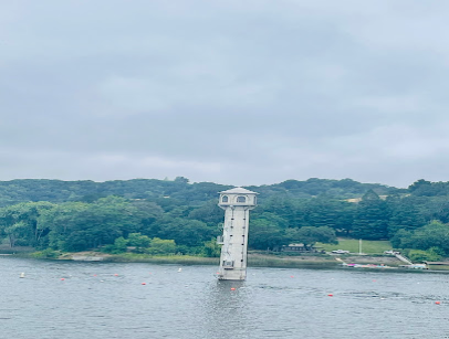 White tower structure in Lafayette Reservoir with forested hills and water backdrop