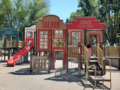 Saloon and Grand Hotel themed playground structure with red slide and wooden deck