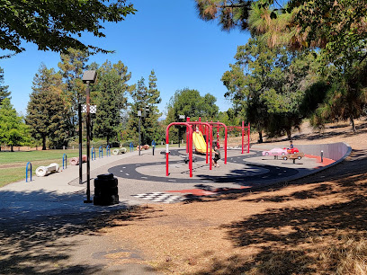 Public park with playground equipment and trees on sunny day